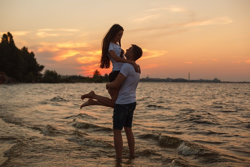 pareja joven abrazados en la orilla de la playa